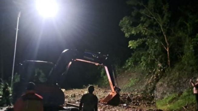 Alat berat jenis excavator sedang membersihkan material batu dan lumpur yang memadati jalan di wilayah Setangi, Kabupaten Lombok Utara, NTB, Minggu (16/10/2022). (ANTARA/HO) 