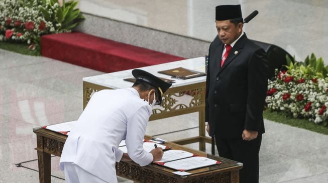 Menteri Dalam Negeri Tito Karnavian (kanan) menyaksikan penandatanganan berita acara pelantikan Penjabat (Pj) Gubernur DKI Jakarta Heru Budi Hartono (kiri) di Kementerian Dalam Negeri, Jakarta, Senin (17/10/2022).  ANTARA FOTO/Rivan Awal Lingga