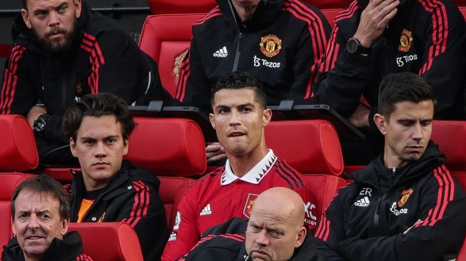 Ekspresi penyerang Manchester United, Cristiano Ronaldo (tengah) di bench usai ditarik keluar pada laga Liga Inggris kontra Newcastle United di Old Trafford, Minggu (16/10/2022) malam WIB. [IAN HODGSON / AFP]