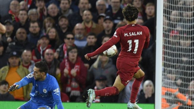 Striker Liverpool asal Mesir, Mohamed Salah (kanan) mencetak gol melewati kiper Manchester City asal Brasil Ederson Moraes (kiri) selama matchday pekan ke-11 Liga Inggris antara Liverpool vs Manchester City di Anfield di Liverpool, Inggris barat laut pada 16 Oktober 2022.Oli SCARFF / AFP.