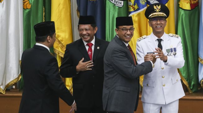 Penjabat Gubernur DKI Jakarta Heru Budi Hartono (kanan) berjabat tangan dengan mantan Gubernur DKI Jakarta Anies Baswedan (kedua kanan) disaksikan Menteri Dalam Negeri Tito Karnavian (kedua kiri) dan mantan Wakil Gubernur Ahmad Riza Patria (kiri) usai dilantik di Kementerian Dalam Negeri, Jakarta, Senin (17/10/2022). ANTARA FOTO/Rivan Awal Lingga