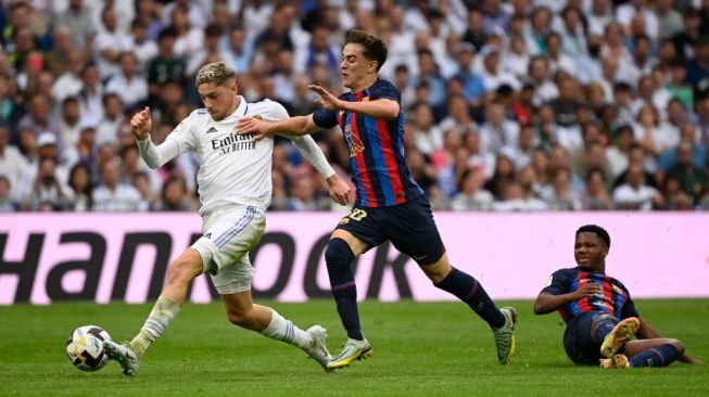 Gelandang Real Madrid, Federico Valverde (kiri) berebut bola dengan gelandang Barcelona Gavi selama matchday pekan ke-9 Liga Spanyol antara Real Madrid vs Barcelona di stadion Santiago Bernabeu pada 16 Oktober 2022.PIERRE-PHILIPPE MARCOU / AFP.