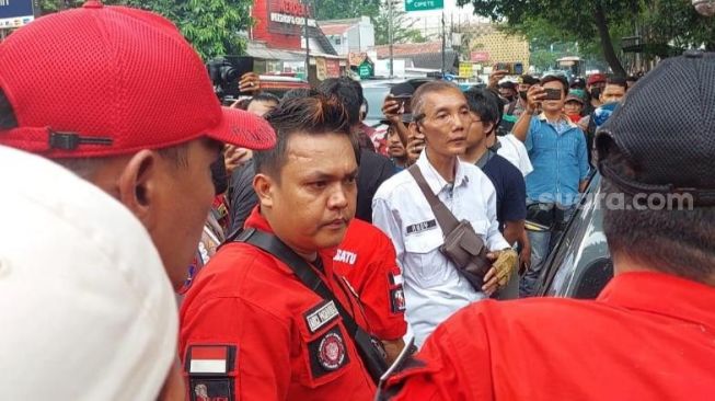 Polisi ringkus pria diduga menjadi penyusup saat demo Pemuda Batak Bersatu di luar sidang Ferdy Sambo. (Suara.com/Arga)