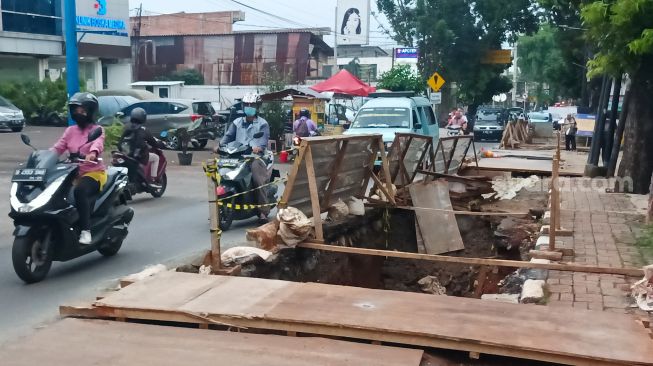 Pengendara melintas disamping proyek galian saluran di Pejaten, Pasar Minggu, Jakarta Selatan, Selasa (18/10/2022). [Suara.com/Alfian Winanto]