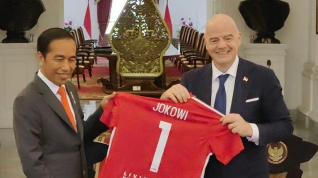 Presiden FIFA Gianni Infantino (kanan) menyerahkan cendera mata berupa jersey FIFA dengan nomor punggung 1 dan nama JOKOWI kepada Presiden RI Joko Widodo selepas pertemuan di Istana Merdeka, Jakarta, Selasa (18/10/2022). [Dok.Antara]