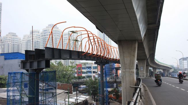 Pekerja menyelesaikan pembangunan jembatan penyeberangan orang (skywalk) yang menghubungkan Stasiun Kebayoran Lama dan Halte Transjakarta di Kebayoran, Jakarta, Selasa (18/10/2022).  ANTARA FOTO/Reno Esnir