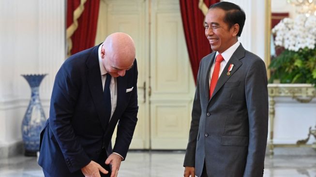 Presiden FIFA, Gianni Infantino (kiri) berbicara dengan Presiden Indonesia, Joko Widodo dalam pertemuan di Istana Merdeka, Jakarta, Selasa (18/10/2022) siang. [ADEK BERRY / AFP]