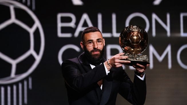 Karim Benzema resmi merengkuh trofi Bola Emas dalam malam gala Ballon d'Or 2022 di Theatre du Chatelet, Paris pada Selasa (18/10/2022) dini hari WIB.  FRANCK FIFE / AFP