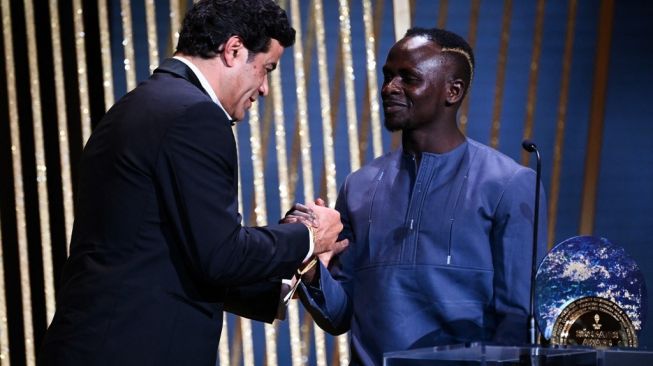 Penyerang Bayern asal Senegal Sadio Mane (kanan) menerima Socrates Trophy untuk pemain yang paling terlibat dalam proyek sosial dan amal dari mantan pemain sepak bola Prancis-Brasil Rai pada upacara penghargaan Ballon d'Or France Football 2022 di Theater du Chatelet di Paris pada 17 Oktober, 2022.FRANCK FIFE / AFP