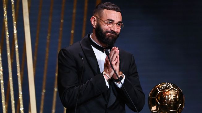 Karim Benzema resmi merengkuh trofi Bola Emas dalam malam gala Ballon d'Or 2022 di Theatre du Chatelet, Paris pada Selasa (18/10/2022) dini hari WIB.  FRANCK FIFE / AFP