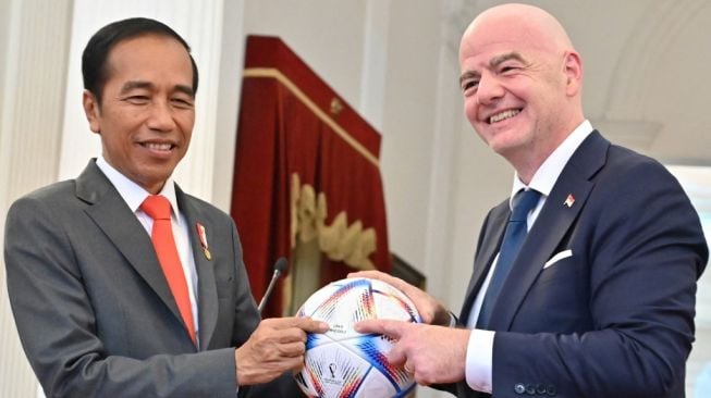 Presiden RI, Jokowi (kiri) bercengkerama dengan Presiden FIFA, Gianni Infantino pada pertemuan di Istana Merdeka, Jakarta, Selasa (18/10/2022). [ADEK BERRY / AFP]