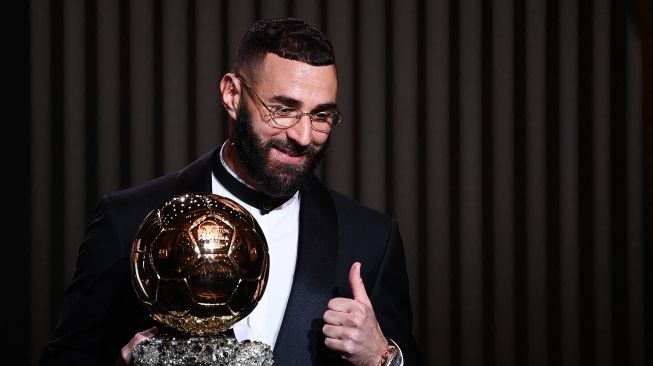 Karim Benzema resmi merengkuh trofi Bola Emas dalam malam gala Ballon d'Or 2022 di Theatre du Chatelet, Paris pada Selasa (18/10/2022) dini hari WIB.  FRANCK FIFE / AFP