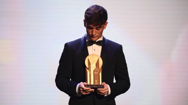 Gelandang Barcelona, Gavi berpose dengan Trofi Kopa dalam seremonial Ballon d'Or 2022 di Theatre du Chatelet, Paris, Prancis, Selasa (18/10/2022) dini hari WIB. [FRANCK FIFE / AFP]