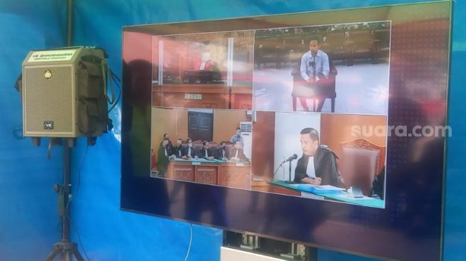 Penampakan suasana sidang Bharada E terdakwa kasus pembunuhan berencana yang ditampilkan melalui layar Tv di luar ruang sidang Pengadilan Negeri Jakarta Selatan. (Suara.com/Arga)