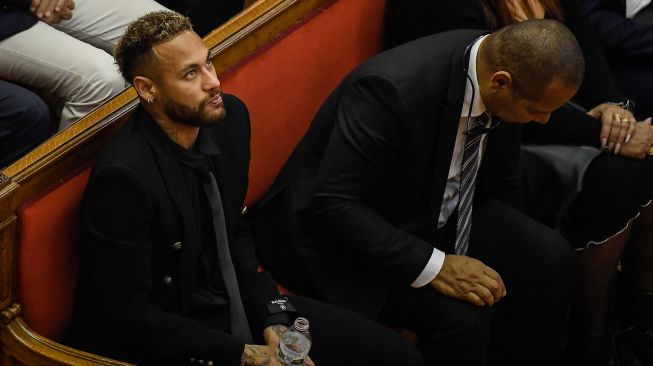 Pesepak bola Paris Saint-Germain Neymar (kiri) bersama ayahnya, mantan pemain sepak bola Brasil Neymar Senior (kanan) saat menghadiri sidang di gedung pengadilan di Barcelona, Spanyol, Senin (17/10/2022). [Josep LAGO / AFP]
