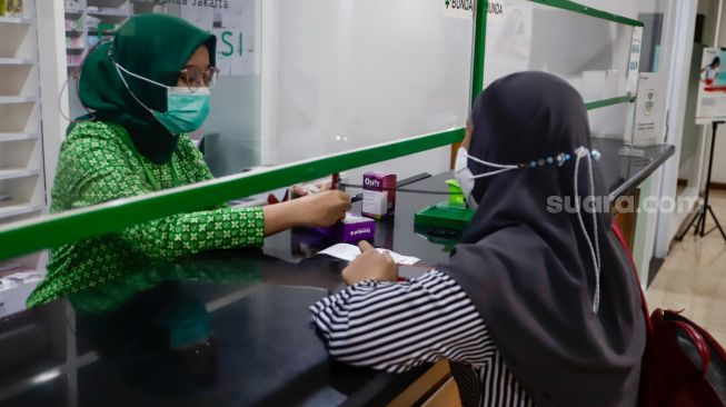 Apoteker melayani pasien yang akan menebus obat di RSIA Bunda, Menteng, Jakarta Pusat, Kamis (20/10/2022).   [Suara.com/Alfian Winanto]