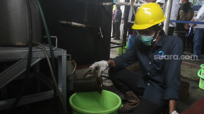 Petugas mengumpulkan bensin dari sampah plastik di IPST Asari, Kotabumi Kecamatan Purwakarta, Kota Cilegon, Banten, Rabu (19/10). [Suara.com/Oke Atmaja]. 