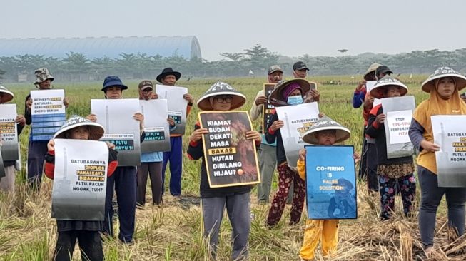 Aksi yang dilakukan Warga Jaringan Tanpa Asap Batu Bara (Jatayu) Indramayu, di lahan milik salah satu warga disekitar area PLTU 1 Indramayu (Suara.com / Danan Arya). 