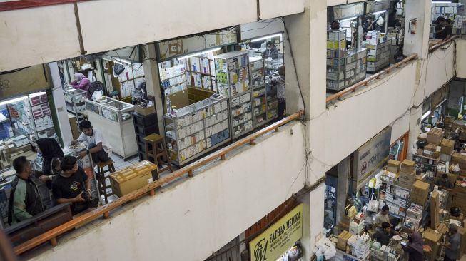 Seorang pedagang menunjukkan surat edaran larangan penjualan obat bebas dalam bentuk sirop di Pasar Pramuka, Jakarta, Jumat (21/10/2022).  ANTARA FOTO/Sulthony Hasanuddin