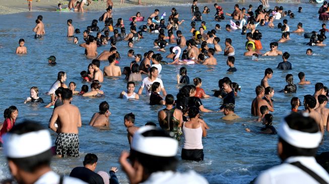 Sejumlah umat Hindu berendam di air saat melakukan ritual Melukat atau menyucikan diri pada Hari Banyu Pinaruh di Pantai Sanur, Denpasar, Bali, Minggu (23/10/2022). [ANTARA FOTO/Fikri Yusuf/tom]