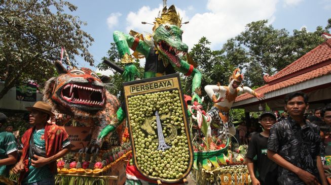 Warga berdiri di dekat berbagai bentuk gunungan saat tradisi Sedekah Bumi di kawasan Made, Surabaya, Jawa Timur, Minggu (23/10/2022). [ANTARA FOTO/Didik Suhartono/tom]