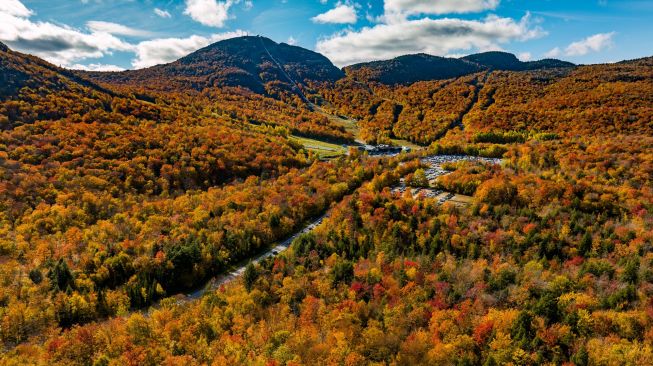 Gambar udara menunjukkan Taman Nasional Mont-Orford yang dikelilingi oleh pepohonan dengan warna musim gugur di Quebec, Kanada, Sabtu (8/10/2022). [Sebastien ST-JEAN / AFP]
