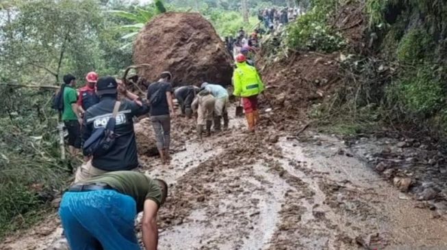 Petugas gabungan bersama warga Kecamatan Naringgul, Cianjur, Jawa Barat, berusaha membuka kembali jalan nasional yang terputus akibat longsor, Sabtu (22/10/22).(ANTARA/Ahmad Fikri). (Ahmad Fikri)