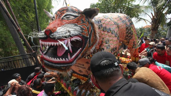 Warga menggotong gunungan berbentuk harimau saat tradisi Sedekah Bumi di kawasan Made, Surabaya, Jawa Timur, Minggu (23/10/2022). [ANTARA FOTO/Didik Suhartono/tom]