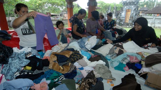  Warga yang terdampak banjir bandang memilih pakaian hasil sumbangan di area Posko Pengungsian Bencana Banjir Bandang, lingkungan Bilukpoh Kangin, Kelurahan Tegal Cangkring, Jembrana, Bali, Sabtu (22/10/2022). [ANTARA FOTO/Nyoman Hendra Wibowo/aww]