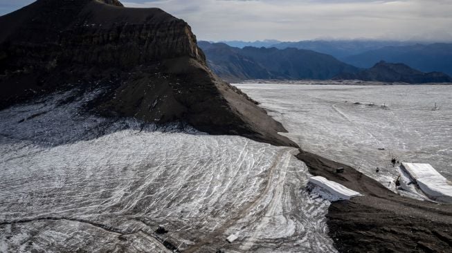 Foto udara menunjukkan selimut yang menutupi es di celah Tsanfleuron untuk mencegahnya mencair di resor Glacier, Les Diablerets, Swiss, Selasa (13/9/2022). [Fabrice COFFRINI / AFP]
