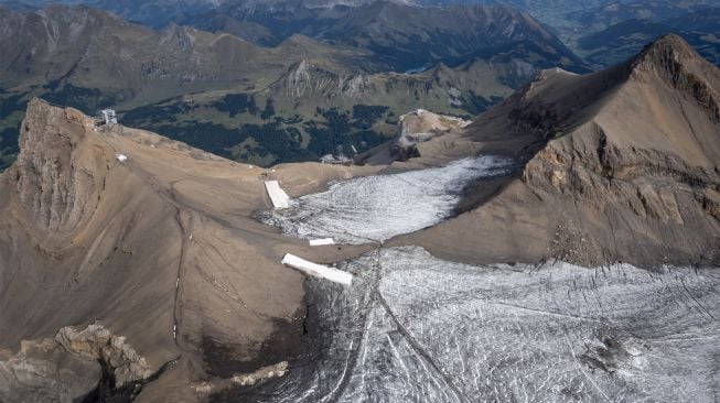 Foto udara menunjukkan selimut yang menutupi es di celah Tsanfleuron untuk mencegahnya mencair di resor Glacier, Les Diablerets, Swiss, Selasa (13/9/2022). [Fabrice COFFRINI / AFP]