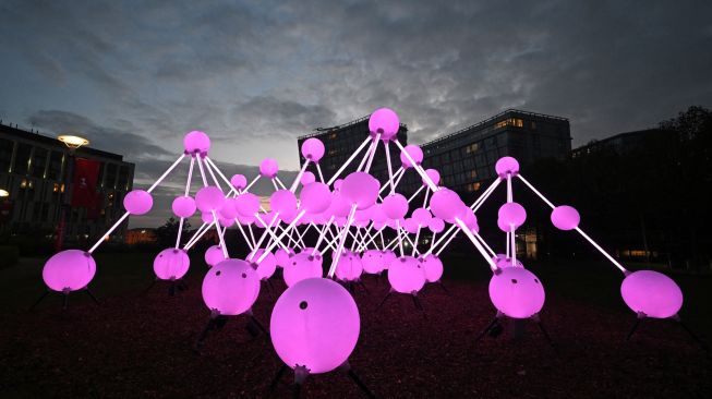 Sebuah karya seni berjudul "Affinity" oleh studio desain Amigo & Amigo dipamerkan saat festival River of light di Liverpool, Inggris, Kamis (20/10/2022). [Paul ELLIS / AFP]