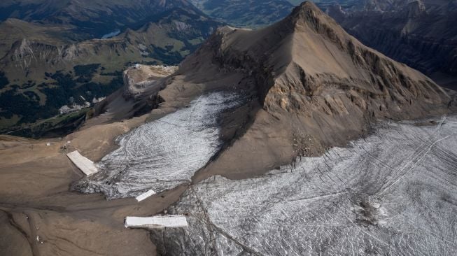 Foto udara menunjukkan selimut yang menutupi es di celah Tsanfleuron untuk mencegahnya mencair di resor Glacier, Les Diablerets, Swiss, Selasa (13/9/2022). [Fabrice COFFRINI / AFP]
