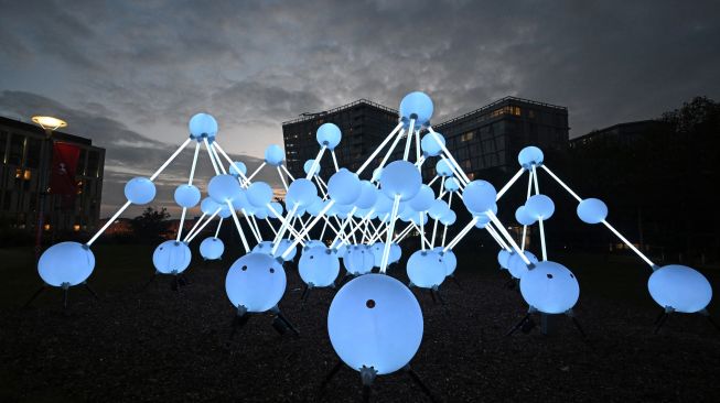 Sebuah karya seni berjudul "Affinity" oleh studio desain Amigo & Amigo dipamerkan saat festival River of light di Liverpool, Inggris, Kamis (20/10/2022). [Paul ELLIS / AFP]