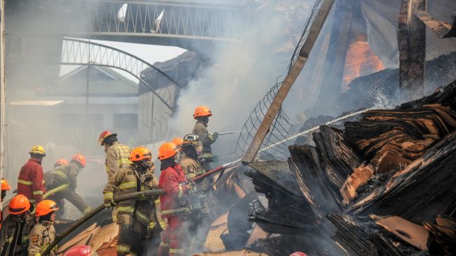 Petugas pemadam kebakaran berusaha memadamkan api yang membakar gudang triplek yang terbakar di Jalan Soekarno-Hatta, Cijagra, Bandung, Jawa Barat, Selasa (25/10/2022). [ANTARA FOTO/Raisan Al Farisi/hp].