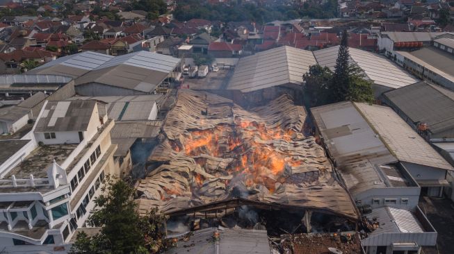 Foto udara gudang triplek terbakar di Jalan Soekarno-Hatta, Cijagra, Bandung, Jawa Barat, Selasa (25/10/2022). [ANTARA FOTO/Raisan Al Farisi/hp].