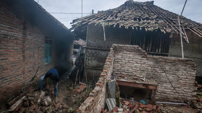 Warga membersihkan puing-puing rumah yang ambruk akibat angin kencang di Sangiang Tanjung, Lebak, Banten, Rabu (26/10/2022). [ANTARA FOTO/Muhammad Bagus Khoirunas]