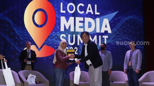 CEO PT Arkadia Digital Media Tbk/Pemimpin Redaksi Suara.com Suwarjono memberikan piagam ke pembicara Direktur Bisnis Beritajatim Saptini Darmaningrum usai seminar di acara Local Media Summit (LMS) 2022 di Perpustakaan Nasional RI,Jalan Medan Merdeka Selatan, Jakarta Pusat, Kamis (27/10/2022). [Suara.com/Alfian Winanto]