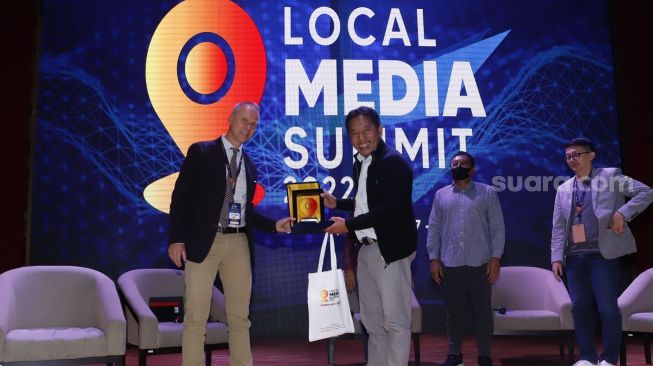 CEO PT Arkadia Digital Media Tbk/Pemimpin Redaksi Suara.com Suwarjono memberikan piagam ke pembicara IMS Head of Department Asia Lars Bestle usai seminar di acara Local Media Summit (LMS) 2022 di Perpustakaan Nasional RI,Jalan Medan Merdeka Selatan, Jakarta Pusat, Kamis (27/10/2022). [Suara.com/Alfian Winanto]