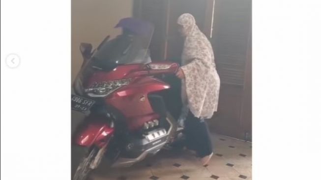 Enteng Banget, Ibu-Ibu Pakai Mukena Santai Parkirkan Moge Suami dengan Standar Tengah