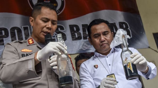 Kapolres Banjar AKBP Bayu Catur Prabowo (kiri) menunjukan barang bukti bom molotov rakitan pada konferensi pers di Makopolres Banjar, Kota Banjar, Jawa Barat, Kamis (27/10/2022). [ANTARA FOTO/Adeng Bustomi/nym].