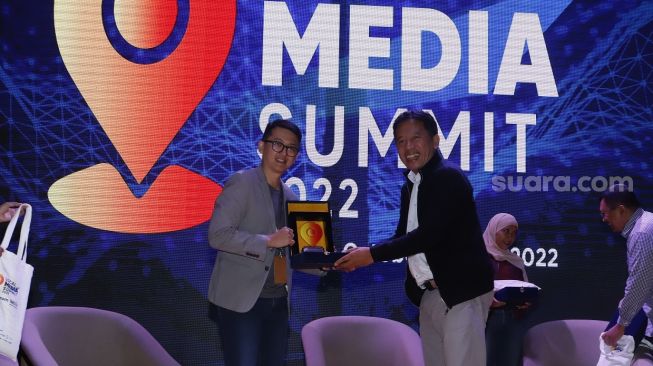 CEO PT Arkadia Digital Media Tbk/Pemimpin Redaksi Suara.com Suwarjono memberikan piagam ke pembicara Country Manager AWS Indonesia Gunawan Susanto usai seminar di acara Local Media Summit (LMS) 2022 di Perpustakaan Nasional RI,Jalan Medan Merdeka Selatan, Jakarta Pusat, Kamis (27/10/2022). [Suara.com/Alfian Winanto]