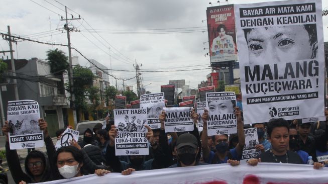 Sejumlah warga dan suporter Arema FC (Aremania) membawa spanduk dan poster saat unjuk rasa di depan Balai Kota Malang, Jawa Timur, Kamis (27/10/2022). Mereka menuntut keadilan dalam tragedi Kanjuruhan. [ANTARA FOTO/Ari Bowo Sucipto/nym].