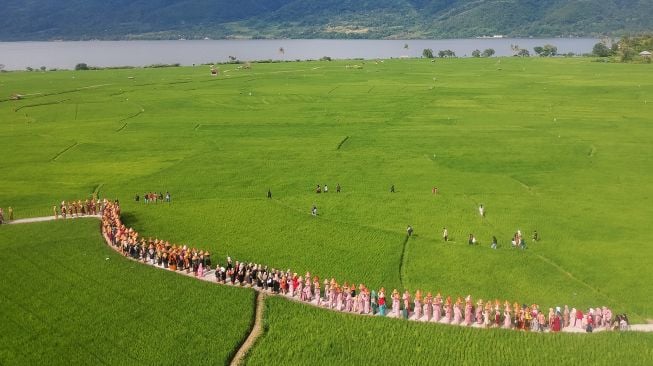 Ibu-ibu menjunjung jamba (makanan) saat mengikuti arak-arakan, pada Festival Galundi Singkarak di Nagari Batu Taba, Kabupaten Tanah Datar, Sumatera Barat, Sabtu (29/10/2022).  ANTARA FOTO/Iggoy el Fitra
