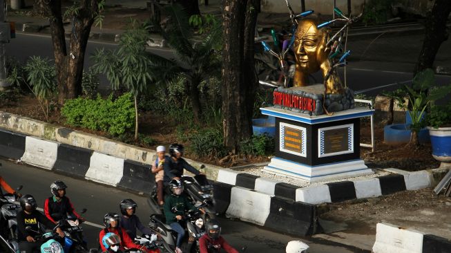 Pengendara melintas di dekat tugu anti knalpot bising di Makassar, Sulawesi Selatan, Sabtu (29/10/2022). ANTARA FOTO/Arnas Padda
