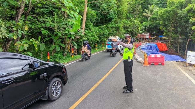 Petugas melakukan rekayasa arus lalu lintas Jalan Jogja-Wonosari di Kecamatan Piyungan, Kabupaten Bantul, Daerah Istimewa Yogyakarta menyusul kejadian longsor pada badan jalan di jalur utama Yogyakarta menuju Gunung Kidul itu. (Foto Humas Polres Bantul)