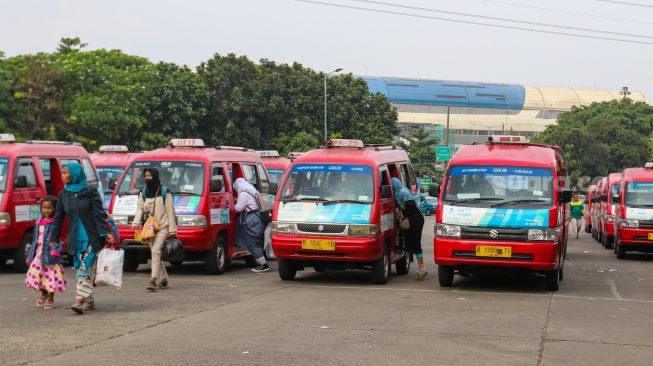 Deretan angkutan umum kota (angkot) JakLingko menunggu penumpang di Terminal Kampung Rambutan, Jakarta Timur, Senin (31/10/2022). [Suara.com/Alfian Winanto]