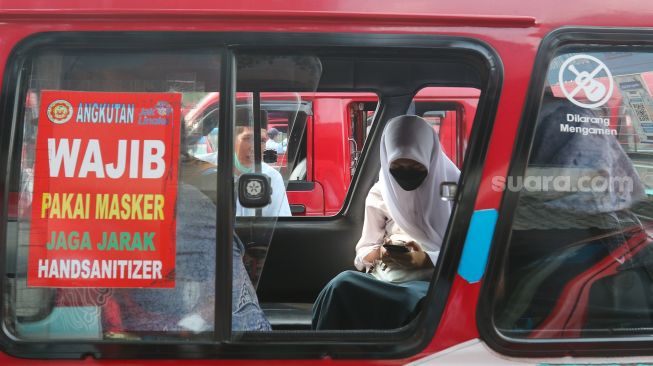 Penumpang menaiki angkutan umum kota (angkot) JakLingko di Terminal Kampung Rambutan, Jakarta Timur, Senin (31/10/2022). [Suara.com/Alfian Winanto]