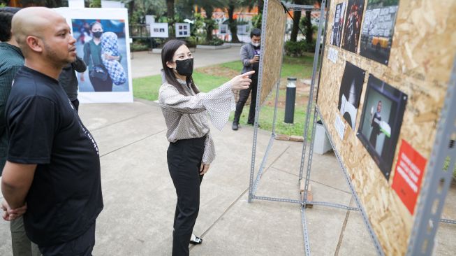 Wakil Mentri Pariwisata dan Ekonomi Kreatif Angela Tanoesoedibjo (tengah) didampingi Ketua PFI Jakarta Herman Zakharia melihat pameran foto jurnalistik Rekam Jakarta 24+ di Taman Lapangan Banteng, Jakarta, Selasa (1/11/2022). [Dok. PFI Jakarta]