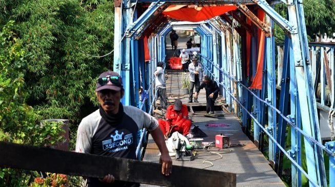 Pekerja memperbaiki Jembatan Ledeng di Kota Bogor, Jawa Barat, Selasa (1/11/2022). Jembatan ini telah berusia ratusan tahun dan dibangun pada jaman Belanda di atas Sungai Cisadane. [ANTARA FOTO/Arif Firmansyah/rwa].